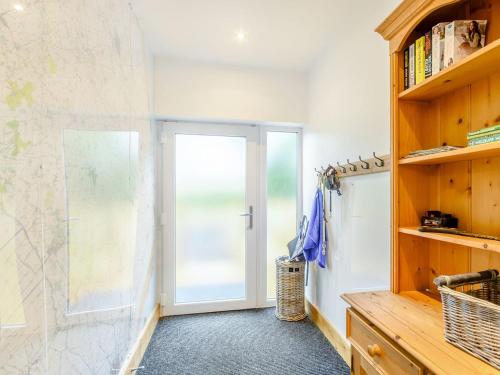 uma casa de banho com uma porta de vidro e uma cabina de duche ao nível do chão em Bournes Homestead em Hagwothingham