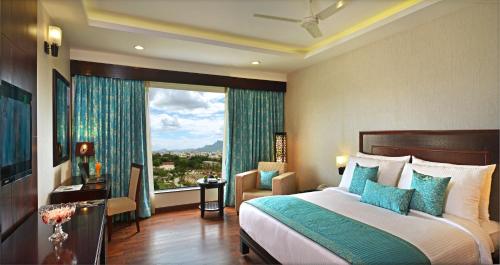 a bedroom with a bed and a large window at Fortune Select Grand Ridge, Tirupati - Member ITC's Hotel Group in Tirupati