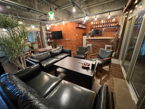 a living room with a leather couch and a table at HOSTEL OE 