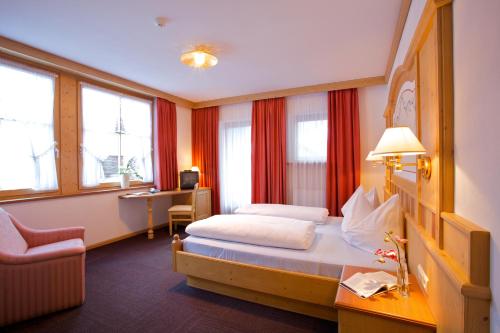 una camera d'albergo con letto e scrivania di Hotel B&B Pardeller a Nova Levante