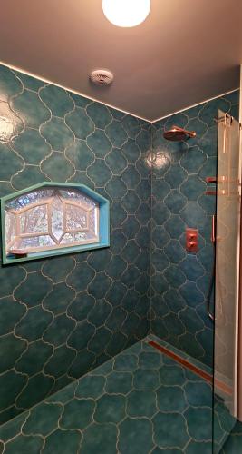 a bathroom with green tiled walls and a window at Wonderland in Pieterburen