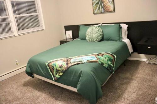 a bedroom with a bed with a green comforter at The Little Amazon in Montgomery