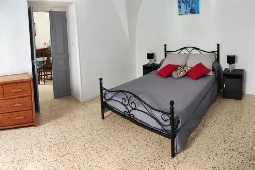 - une chambre avec un lit doté d'oreillers rouges dans l'établissement le gite de flavie, à Montpeyroux