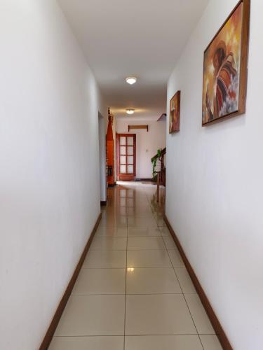 a hallway with white walls and a painting on the wall at Antsirabe Hotel in Antsirabe