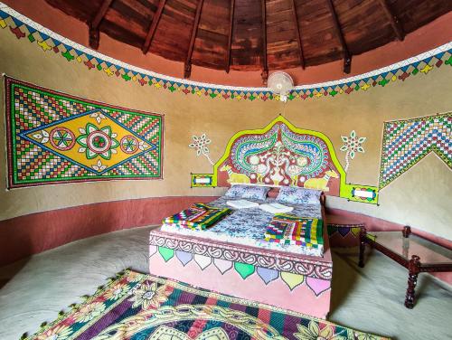a bedroom with a bed with colorful designs on the wall at Royal King in Dhordo