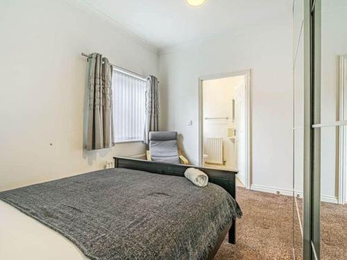 a bedroom with a bed and a chair and a mirror at Numero Uno Detached Aparthouse in Newcastle upon Tyne