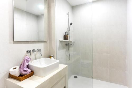 a white bathroom with a sink and a shower at 4Guests BeachFront SK HuaHin by น้องมังคุด in Hua Hin