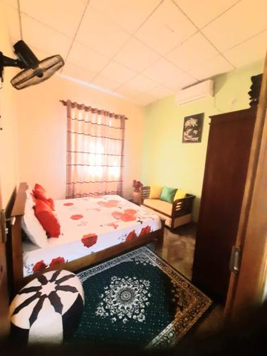 1 dormitorio con cama y sofá en Happy Nest, en Talagala