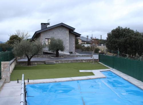 una piscina frente a una casa en Casa con vistas a la Sierra de Guadarrama en Guadarrama