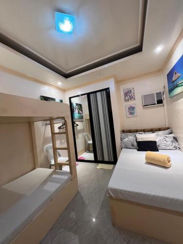 a bedroom with two beds and a bunk bed at Palompon Sugar's Inn in Palompon