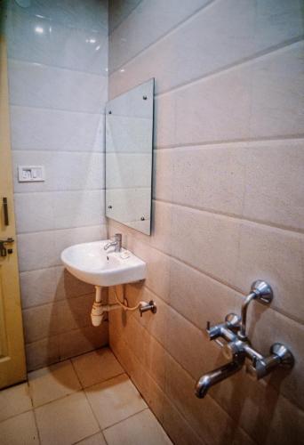 a bathroom with a sink and a mirror on the wall at HOTEL PRAKAASH COMFORTS in Vānivilāsa Puram