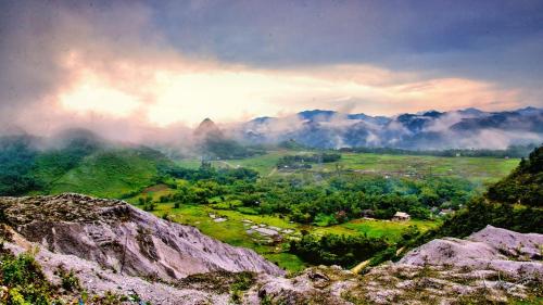 a view of a valley from a mountain with clouds at Thao Ly Homestay Mai Chau in Hòa Bình