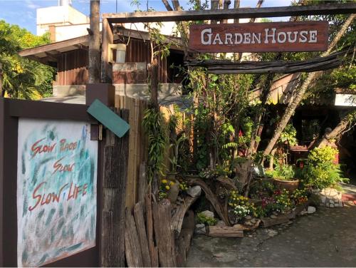 a garden house with a sign and some plants at Garden House INChiangrai in Chiang Rai