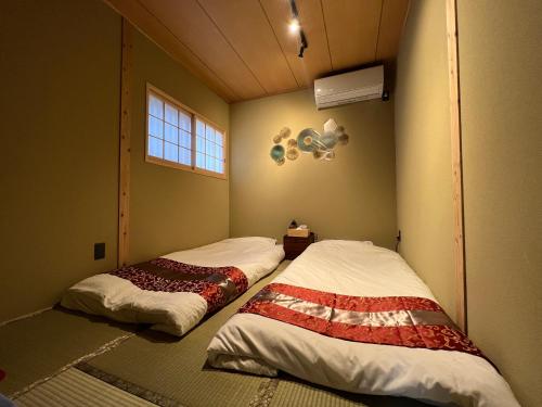 two beds in a corner of a room at 至の宿-京都南 Traditional Machiya Guesthouse in Kyoto