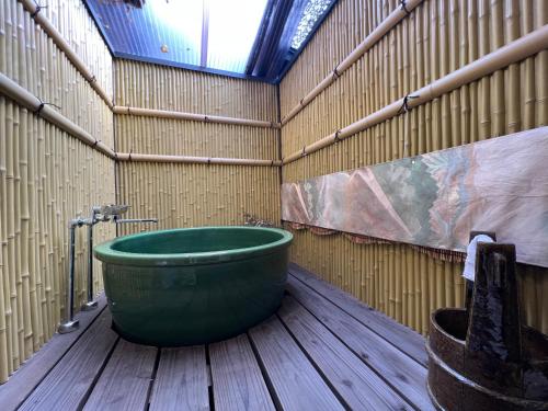 a large green tub sitting inside of a building at 至の宿-京都南 Traditional Machiya Guesthouse in Kyoto