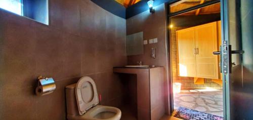 y baño con aseo, lavabo y ducha. en Gipir and Labongo Safari Lodge Ltd, en Pakwach East