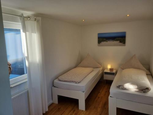 een kleine kamer met 2 bedden en een raam bij Hafenkieker in Greetsiel