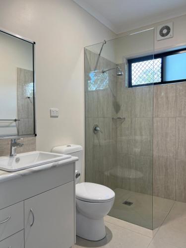 a bathroom with a toilet and a glass shower at The Orchid Suite - Apartment in Cooktown in Cooktown