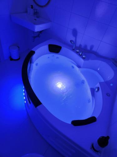 a bath tub with a blue light in a bathroom at Zámek Ruda nad Moravou in Ruda na Moravě