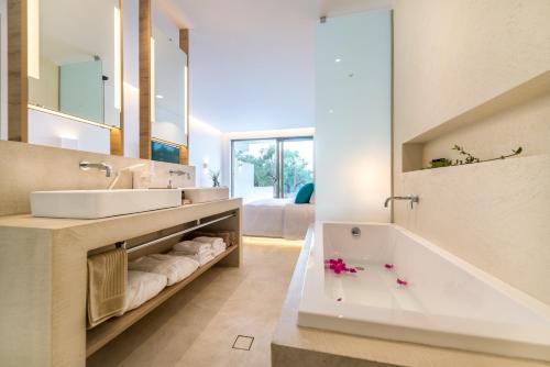 a bathroom with two sinks and a bath tub at Tsamis Zante Suites in Kypseli