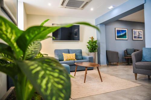 a waiting room with blue chairs and a table at The Howard Hotel in Sliema