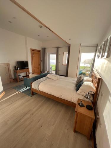 a bedroom with a large bed and a large window at Coed y Berclas guest room, wonderful view in Llandegfan