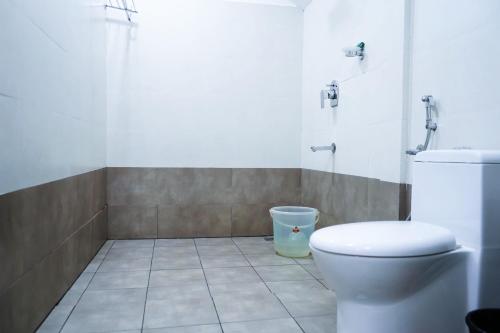 a bathroom with a toilet and a trash can at Edens Munnar in Munnar