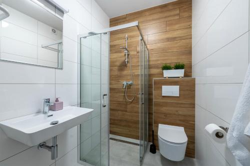y baño con ducha, aseo y lavamanos. en Apartamenty RIO Skarbimierz-Osiedle en Skarbimierz Osiedle