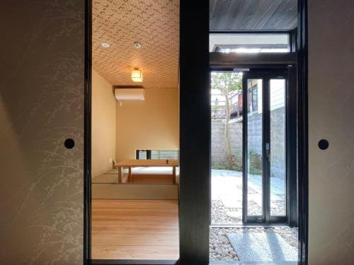 una puerta de cristal que da a una habitación con un banco en 橋旅西雅院 Kyoryosaiga Inn, en Kioto
