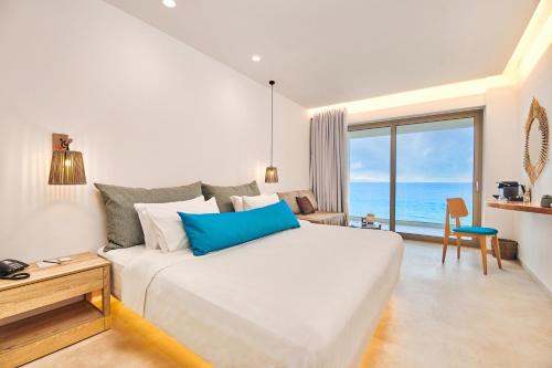 a bedroom with a large bed with a view of the ocean at Tsamis Zante Suites in Kipseli