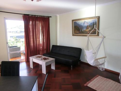 - un salon avec un canapé noir et un hamac dans l'établissement Formosa Sunset, à Funchal