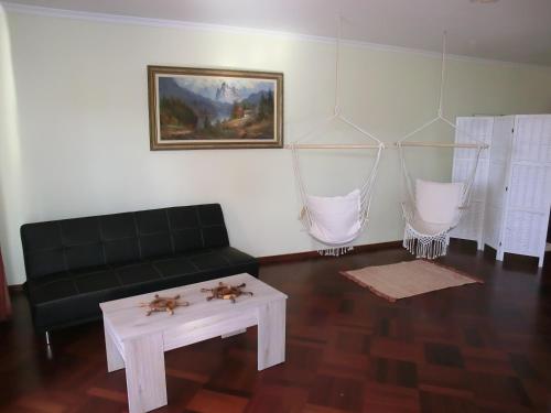 een woonkamer met een zwarte bank en een tafel bij Formosa Sunset in Funchal