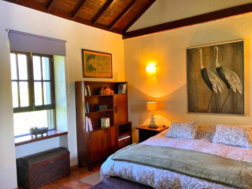 a bedroom with a bed and a painting on the wall at Casa Rural CaChispita in Teror