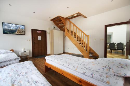 a bedroom with two beds and a staircase at Kościuszki 3 Apartamenty in Lądek-Zdrój