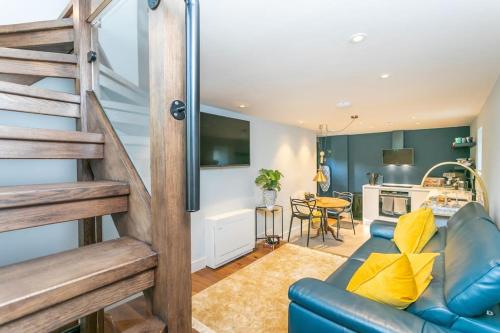 ein Wohnzimmer mit einer blauen Couch und einer Küche in der Unterkunft Luxurious one bedroom house in Embsay