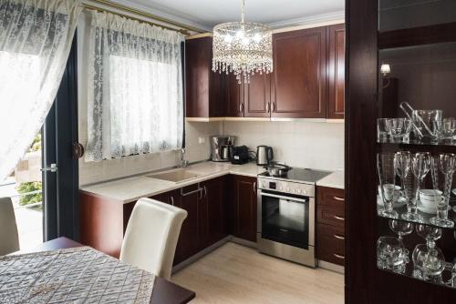 a kitchen with wooden cabinets and a chandelier at Luxury Dafnis House in Veria