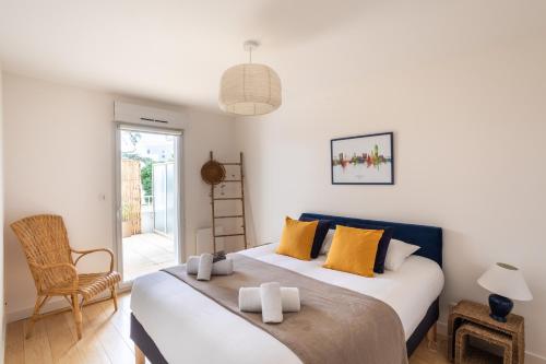 una camera da letto con un grande letto con cuscini gialli di Le Jardin d'Ulysse - 2 chambres avec parking a Nantes