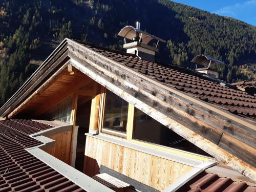 a roof of a house with mountains in the background at Alpenhaus Christian in Neustift im Stubaital