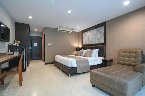 a bedroom with a bed and a desk and a couch at Aranta Suvarnabhumi in Lat Krabang