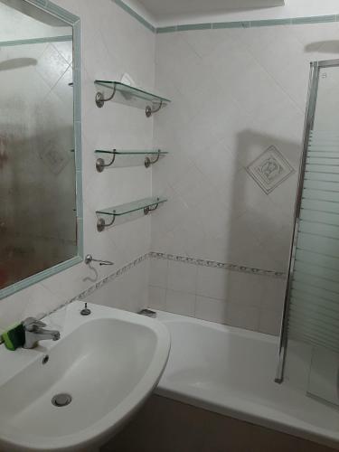 a white bathroom with a sink and a shower at Dan Ravello in Ravello