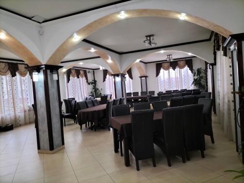 a dining room with black tables and chairs at Pensiune Stirbu in Borsa