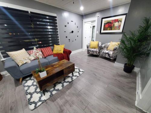 a living room with a couch and a table at PRIVATE & COMFORTABLE Full house near Royal Alexandra Hospital Stadium Downtown & Mall Access in Edmonton