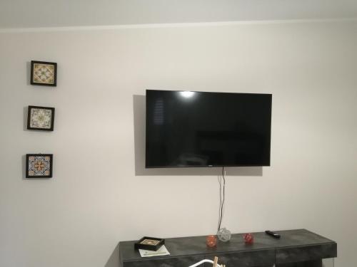 einen Flachbild-TV, der an einer weißen Wand hängt in der Unterkunft Casa sul Corso in Melito di Porto Salvo