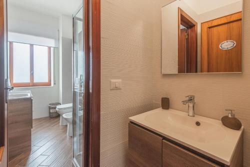 a bathroom with a sink and a mirror and a toilet at Pappacoda 7 - Lecce Selection in Lecce