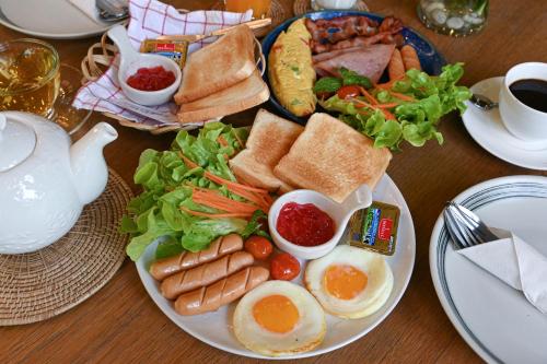 a plate of breakfast food with eggs and a salad at Aranta Suvarnabhumi in Lat Krabang