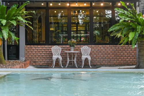 two chairs and a table in front of a building at Aranta Suvarnabhumi in Lat Krabang