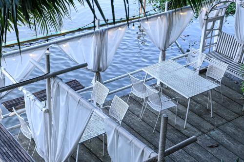 a table and chairs on a dock next to the water at Aranta Suvarnabhumi in Lat Krabang
