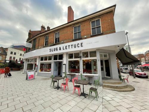a store with chairs and tables in front of a building at Stylish 1 bedroom flat with free parking in Woking