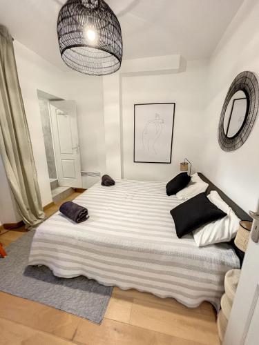une chambre avec un grand lit blanc avec des oreillers noirs dans l'établissement Clémenceau by Olam Properties 3 pcs Rénové 2022, à Cannes