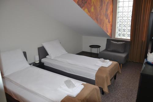 a hotel room with two beds and a chair at Bursztynowa in Łuków